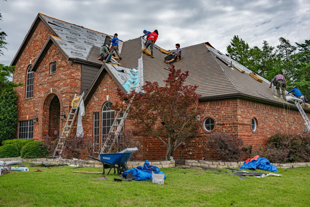 Crew re-roofing a large brick home