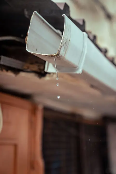 White gutter dripping after rain