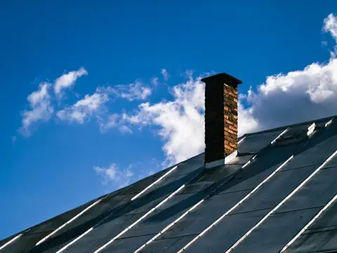 Standing seam metal roof with a brick chimney