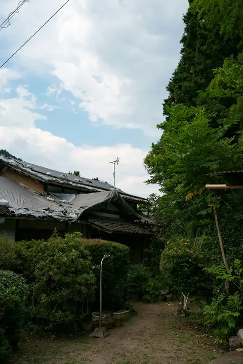 Old house with a tarp over its roof